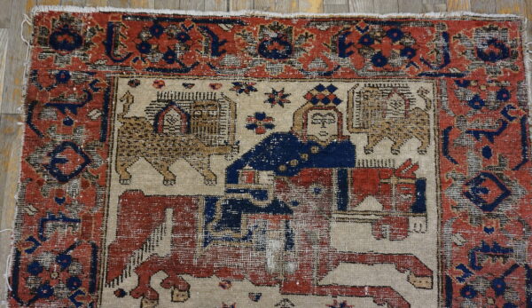 Distressed rug with rust red border and a central beige field depicting a figure on a horse and leopards.