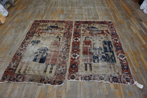 A low-pile, distressed rug with faded red, blue, and tan figurative patterns rests on wood planks.