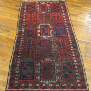 A runner rug with red, navy, and dark brown geometric tribal patterns rests on light wood plank flooring.