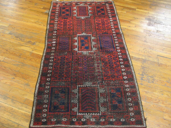 A runner rug with red, navy, and dark brown geometric tribal patterns rests on light wood plank flooring.