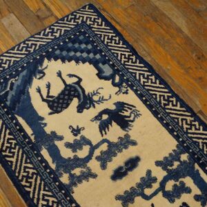Blue and cream runner rug with stylized deer and bird motifs, surrounded by complex geometric borders on wood flooring.