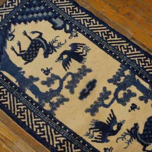 A blue and beige pictorial runner featuring deer and birds lies on a distressed wooden floor.