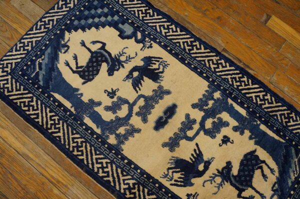 A blue and beige pictorial runner featuring deer and birds lies on a distressed wooden floor.