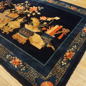 Plush navy rug with ornate gold, orange, and blue pictorial designs rests on light hardwood floors.