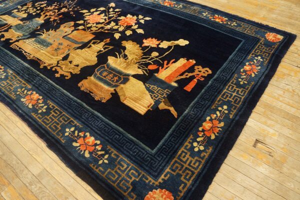 Plush navy rug with ornate gold, orange, and blue pictorial designs rests on light hardwood floors.