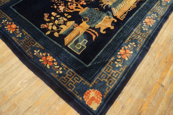 Deep blue rug featuring gold, teal, and orange motifs with ornate floral and fretwork borders on wood planks.
