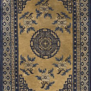 Tan rug with navy geometric borders and blue and cream floral patterns surrounding a central medallion.
