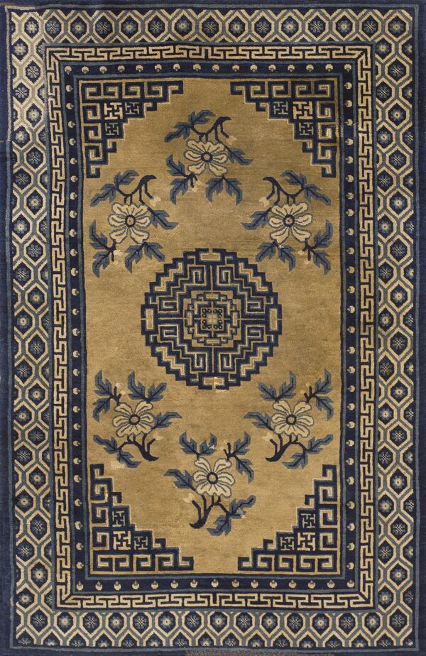 Tan rug with navy geometric borders and blue and cream floral patterns surrounding a central medallion.