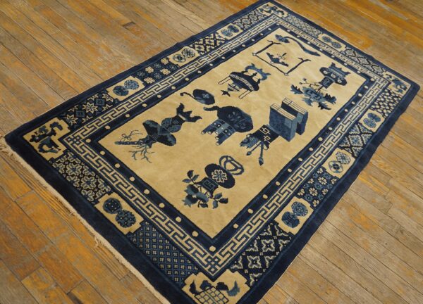 A rectangular blue and beige rug with geometric borders and scattered symbols lies on distressed wood floors.