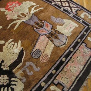 Textured brown rug with abstract floral patterns in muted pink, beige, and gray on light wood flooring.