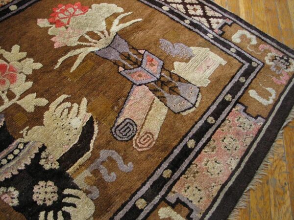 Textured brown rug with abstract floral patterns in muted pink, beige, and gray on light wood flooring.