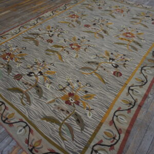 Large gray and cream rug featuring gold and maroon florals and a vine border on distressed gray planks.