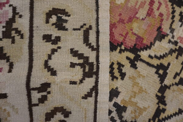 Flatweave rug detail featuring abstract borders in dark brown on beige, next to red and gold geometric patterns.