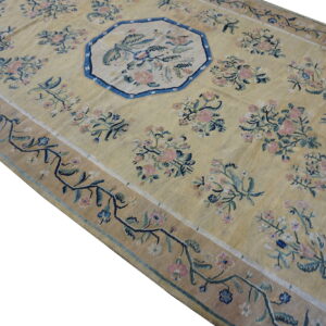Pale yellow rug with scattered pink and blue floral bouquets, wide border, and central octagonal medallion.