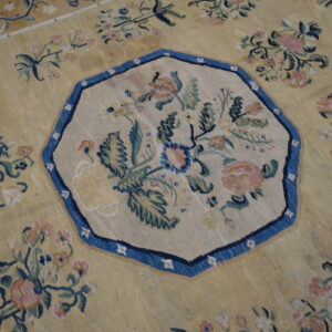 Ornate yellow rug with an octagonal blue-bordered medallion centered with pink and green floral bouquets.