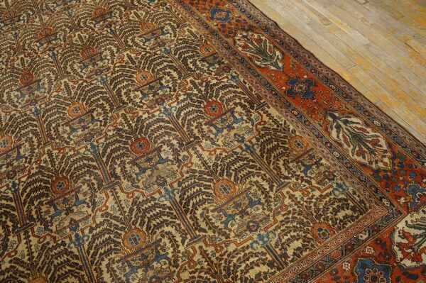 Detailed rug showing brown and blue stylized repeating motifs on a beige field with a rust border on wood flooring.