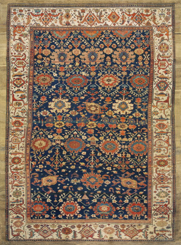 Deep navy rug with intricate rust and beige floral medallions, featuring a multi-colored geometric border on a tan background.
