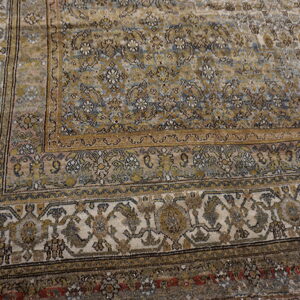 Distressed rug featuring intricate gold, dusty blue, and cream traditional patterns and layered borders.