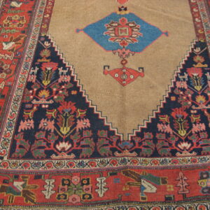 Geometric rug showing a tan central field, serrated navy edge, red border, and colorful stylized animal motifs.