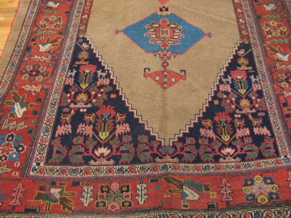 Geometric rug showing a tan central field, serrated navy edge, red border, and colorful stylized animal motifs.