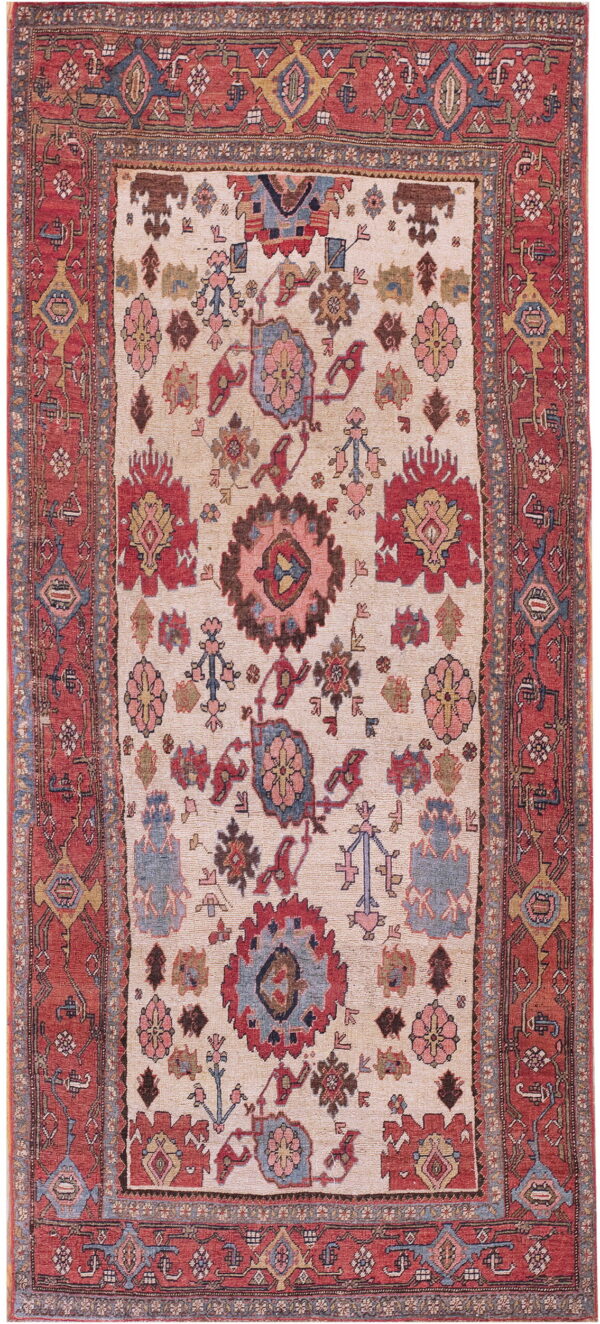 Low-pile rug with an ivory field and multicolored floral medallions within a wide red border.
