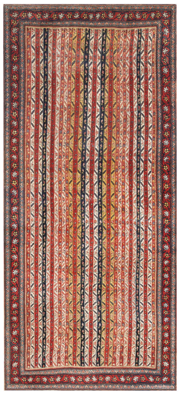 Low-pile rug featuring vertical stripes of red, navy, gold, and cream with a complex floral border.