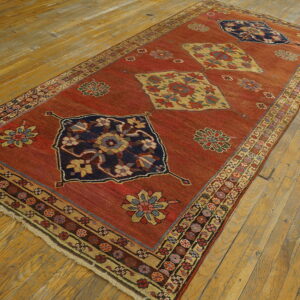 Red runner rug featuring navy and yellow geometric medallions displayed on light, distressed hardwood planks.