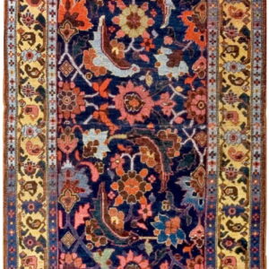 Long runner rug displays a dense botanical design on a deep blue ground with wide yellow borders.