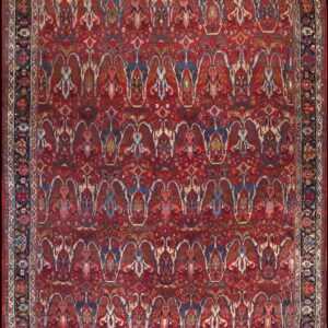 Traditional red rug with an all-over pattern of stylized multicolored floral motifs and a wide dark blue border.