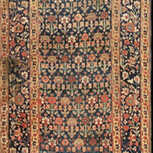 Dark blue runner rug with repeating rust and gold floral patterns and multi-layered borders.