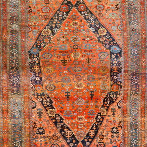 High-pile rug in deep orange, navy, and teal with an elaborate traditional diamond medallion design.