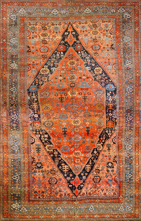 High-pile rug in deep orange, navy, and teal with an elaborate traditional diamond medallion design.
