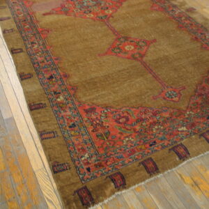 Traditional brown rug with red floral medallions and borders sits on rustic wood plank flooring.