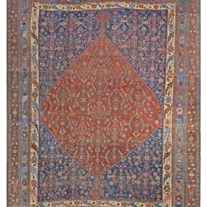 Full view of a rug with a terracotta center medallion and navy blue field with detailed borders.