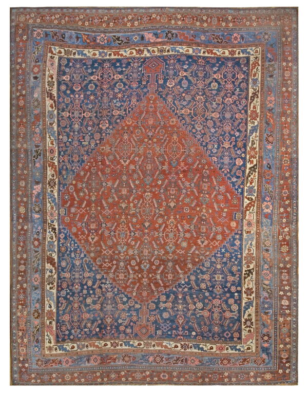 Full view of a rug with a terracotta center medallion and navy blue field with detailed borders.