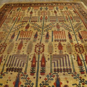 A large golden rug with detailed red, blue, and green vertical tree patterns is displayed on wood planks.
