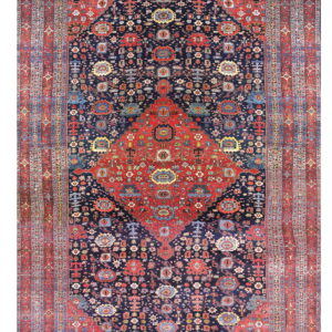 Red and dark blue traditional rug featuring a detailed central medallion and wide patterned borders.