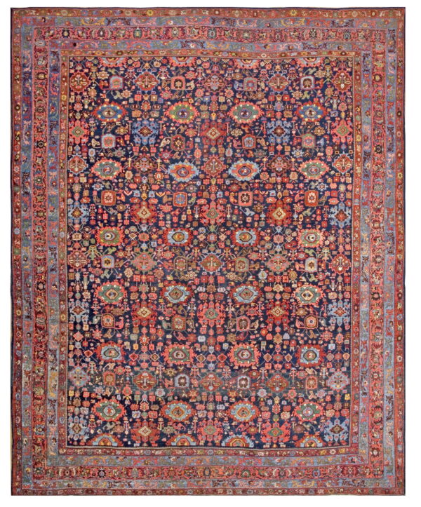 A densely patterned navy rug featuring repeating red, blue, green, and gold geometric and stylized motifs.