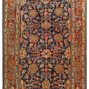 Detailed, medium-pile rug featuring red and green ornate florals on a navy-blue central field and rust borders.
