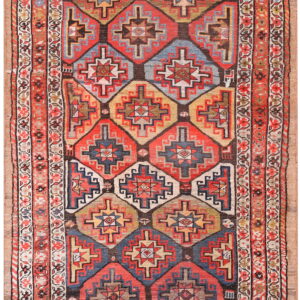 Red, blue, and tan geometric rug featuring a vertical arrangement of large diamond medallions.
