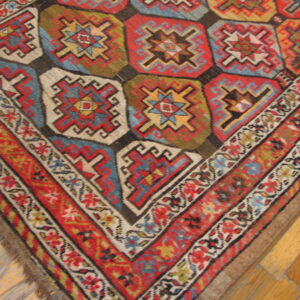 Flat texture rug corner featuring colorful geometric medallions and patterned borders rests on wood planks.