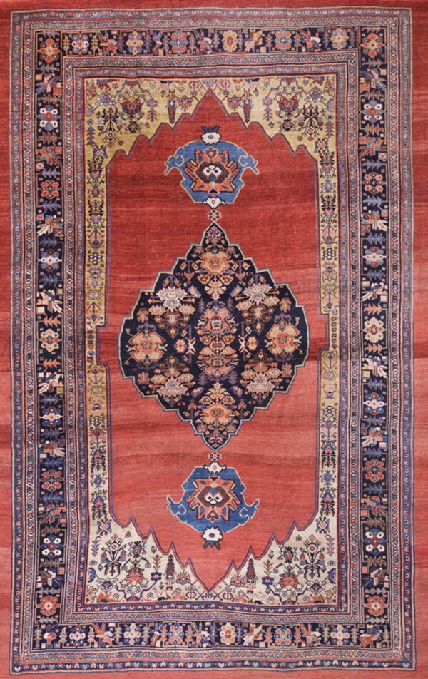 Rust-red rug with a navy medallion and stylized borders, including cream and gold arch patterns.