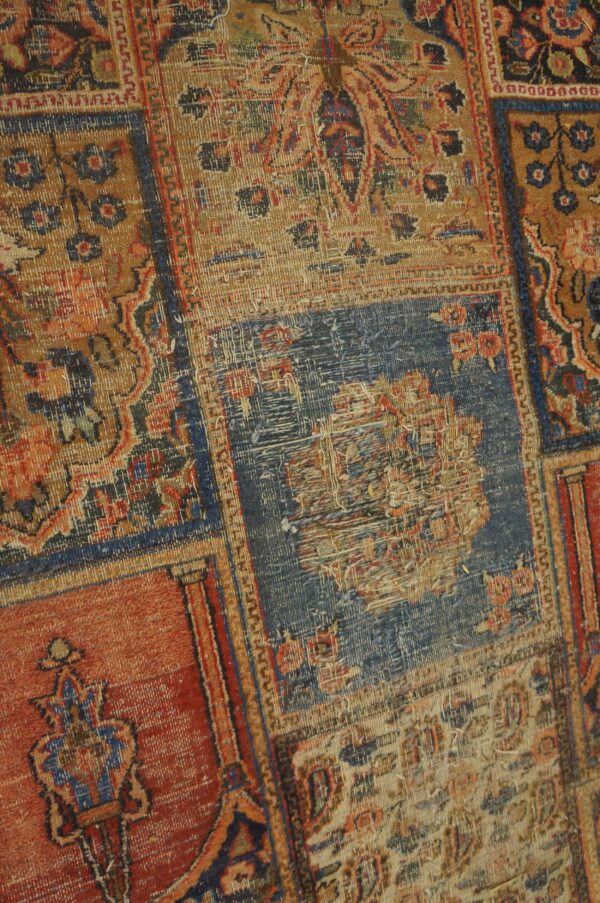 Heavily distressed patchwork rug closeup featuring traditional motifs in faded blue, rust, and tan colors.
