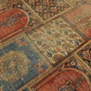 Distressed patchwork rug detail showing red, blue, tan, and dark squares with traditional motifs.
