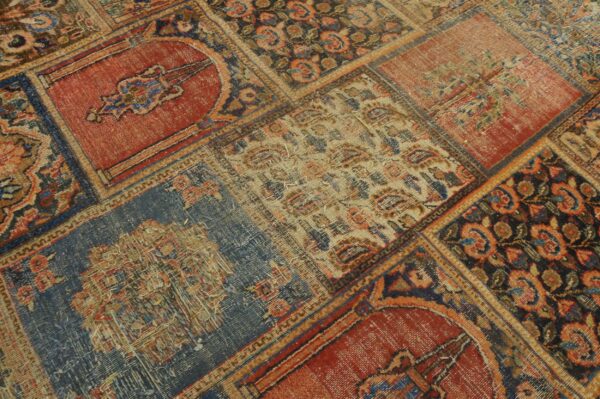 Distressed patchwork rug detail showing red, blue, tan, and dark squares with traditional motifs.