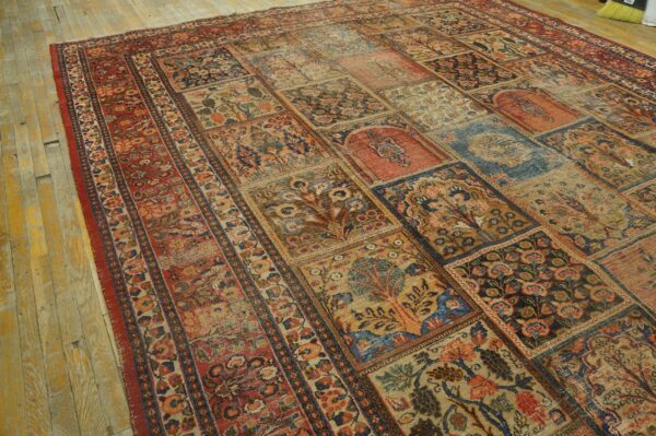 Multicolored paneled rug with floral and tree motifs lies on distressed yellow-toned hardwood flooring.