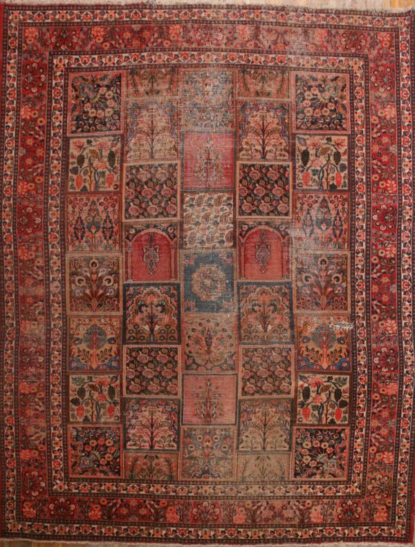 Faded red and navy rug featuring a floral grid panel design with tree motifs and a wide decorative border.