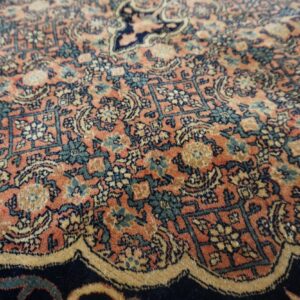 Ornate rug detail in terracotta, deep blue, teal, and gold with complex repeating floral motifs.