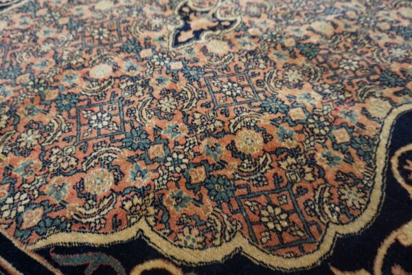 Ornate rug detail in terracotta, deep blue, teal, and gold with complex repeating floral motifs.