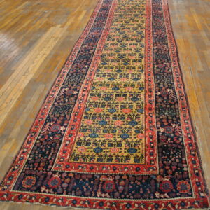 Traditional runner featuring a dense navy border and a central yellow field sits on hardwood flooring.